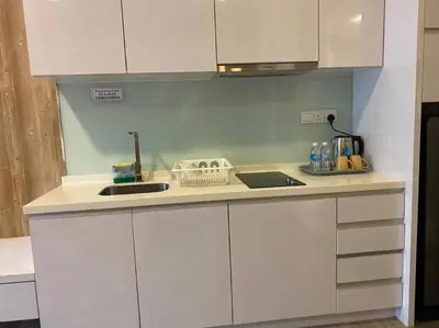 a kitchen with white cabinets and a counter top at One Bukit Ceylon At Pavilion Bukit Bintang in Kuala Lumpur