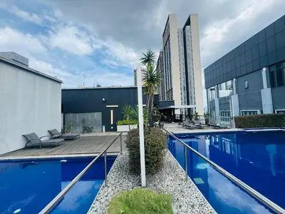 a large swimming pool with blue water in a building at Bukit Bintang Fairlane KLCC suites by Angel in Kuala Lumpur