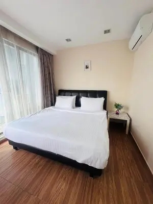 a bedroom with a large bed with white sheets at Bukit Bintang Fairlane KLCC suites by Angel in Kuala Lumpur