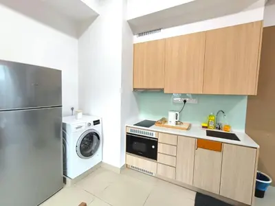 a kitchen with a washing machine and a washer at Alaman Luxe suites KLCC in Kuala Lumpur