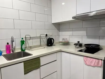 a white kitchen with a sink and a stove at Arte Mont Kiara By Luxe Home in Kuala Lumpur