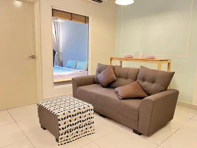 a couch and a stool in a living room at Arte Mont Kiara By Luxe Home in Kuala Lumpur