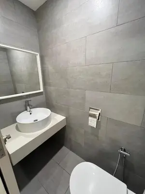 a bathroom with a sink and a toilet and a mirror at Arte Mont Kiara By Luxe Home in Kuala Lumpur