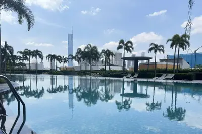 a large swimming pool with palm trees and a city at Comfy studio suite Free Parking Netflix Trion C3208St KL in Kuala Lumpur