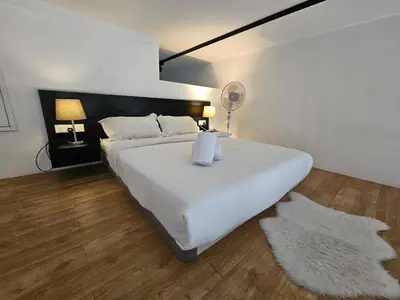 a bedroom with a large white bed with two white rugs at Scenic Garden Balcony EST Bangsar Studio for 2 in Kuala Lumpur