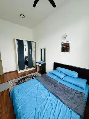 a bedroom with a large bed with blue pillows at VUE Residences Hkl Klcc view in Kuala Lumpur