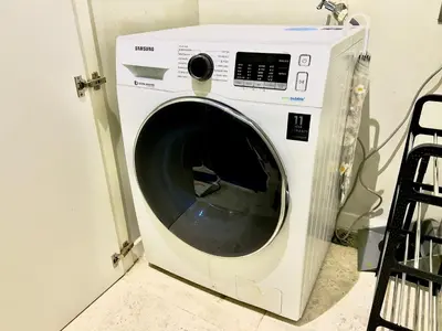 a white washing machine sitting in a room at Sky Suites Chill 3BR Suite at KLCC in Kuala Lumpur