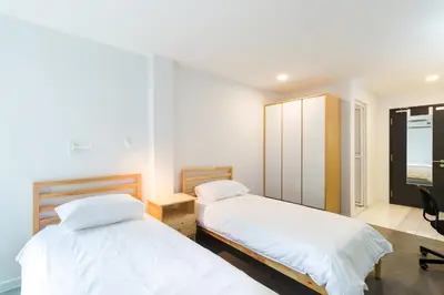 a bedroom with two beds and a desk and a mirror at Upstairs Downstairs CoLiving Kampung Pandan in Kuala Lumpur