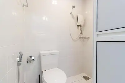 a white bathroom with a toilet and a phone at Upstairs Downstairs CoLiving Kampung Pandan in Kuala Lumpur
