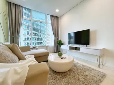 a living room with a couch and a tv at Sky Suites Dreamy 3BR Suite at KLCC in Kuala Lumpur