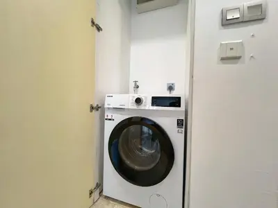 a washing machine in a room with a door at Sky Suites Dreamy 3BR Suite at KLCC in Kuala Lumpur