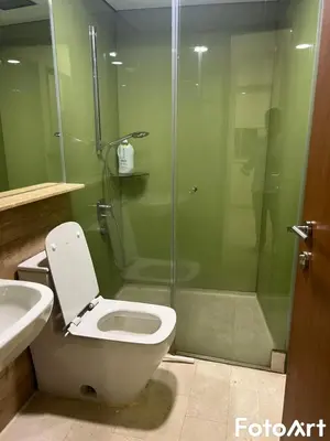 a bathroom with a toilet and a glass shower at Sky Suites KLCC by ARBA in Kuala Lumpur