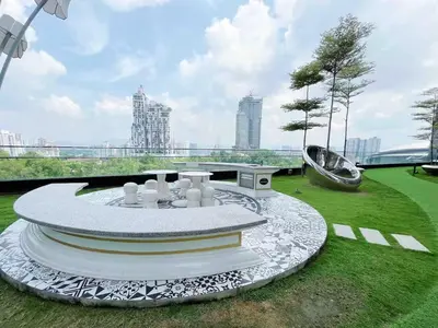a garden with a circular table in the grass at Arte mont kiara by Happy stay in Kuala Lumpur