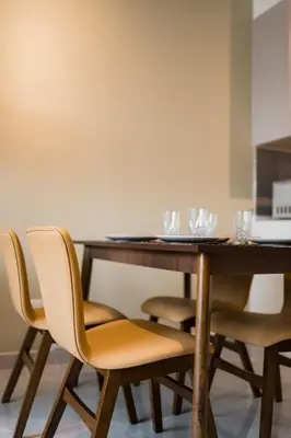 a dining room table with four chairs and glasses on it at Agile BB Residence Pavilion TRX by GB in Kuala Lumpur