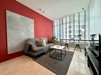 a living room with a chair and a table at Sky Suites Lovely 3BR Suite at KLCC in Kuala Lumpur