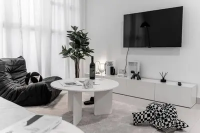 a white living room with a table and a tv at Trion KL - 2 Bedroom, 5 pax, Netflix, Free Car Park in Kuala Lumpur