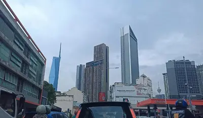 a busy city street with cars driving down a street with tall buildings at D'Majestic Place in Kuala Lumpur