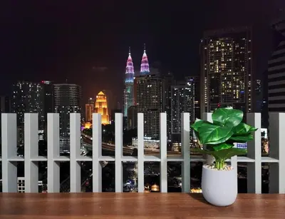 a white fence with a potted plant in front of a city skyline at COL 14A Modern Infinity Pool KLCC View with Balcony in Kuala Lumpur
