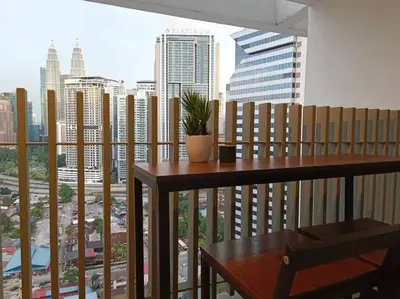 a balcony with a table and a view of a city at COL 14B Modern Infinity Pool KLCC Balcony View in Kuala Lumpur