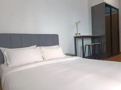 a large white bed with white pillows and a table at LUX 39B KLCC view Studio in Kuala Lumpur