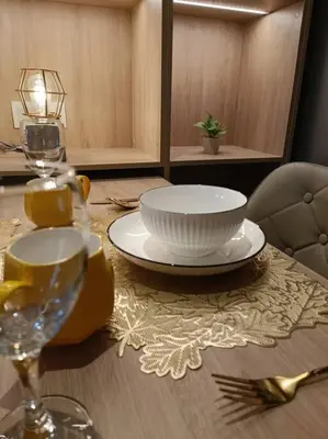 a table with a bowl and a plate on it at COL137A Modern Balcony KLCC View & Infinity Pool in Kuala Lumpur