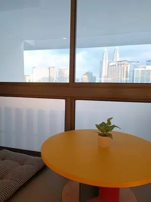 a yellow table with a potted plant on it in front of a window at COL 137B Modern Balcony KLCC View & Infinity Pool in Kuala Lumpur