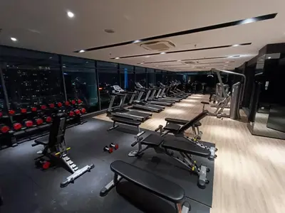 a gym with a row of treadmills and machines at COL 137B Modern Balcony KLCC View & Infinity Pool in Kuala Lumpur