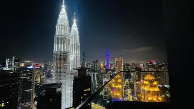 a view of the petronas twin towers at night at Star Serviced Suite KLCC in Kuala Lumpur