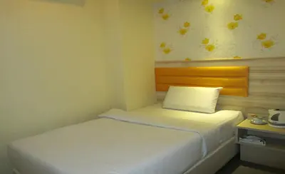 a small bedroom with a white bed and a pillow at T-Hotel Bukit Bintang in Kuala Lumpur