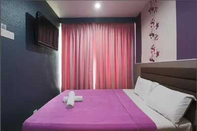 a bedroom with a bed with a purple blanket at T-Hotel Bukit Bintang in Kuala Lumpur