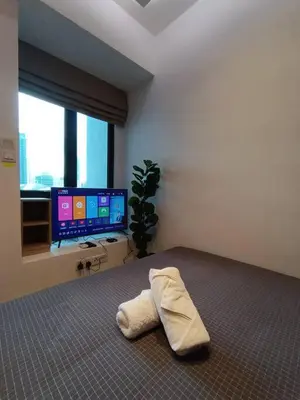 a bedroom with a bed with a tv and a pillow at COL 915B Studio Balcony Infinity Pool KLCC View in Kuala Lumpur