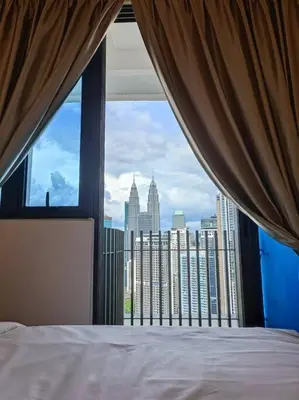 a bedroom with a view of the city from a window at COL 29B Cozy Studio with KLCC Balcony View in Kuala Lumpur