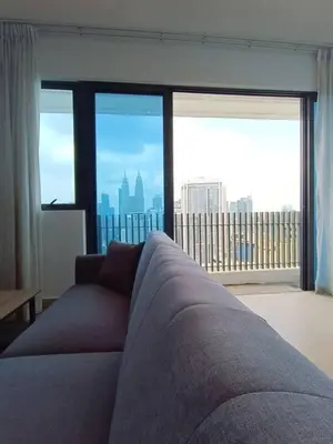 a living room with a couch in front of a large window at COL 30A Super Balcony KLCC KL Tower View in Kuala Lumpur