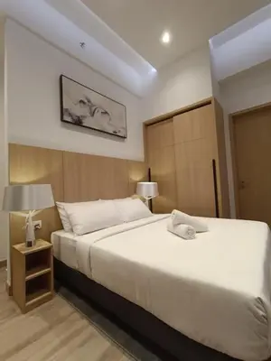 a bedroom with a large white bed and a lamp at COL 30B KL Tower View Cozy Studio in Kuala Lumpur