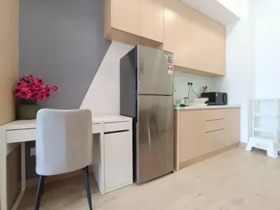 a kitchen with a stainless steel refrigerator and a chair at COL 23aA Cozy KLCC View & Infinity Pool Studio in Kuala Lumpur