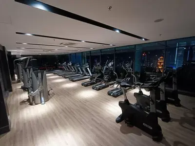 a gym with a row of treadms and cardio machines at COL 23aA Cozy KLCC View & Infinity Pool Studio in Kuala Lumpur