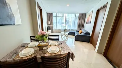 a dining room table with chairs and a living room at Vortex Suites klcc By Sayang in Kuala Lumpur