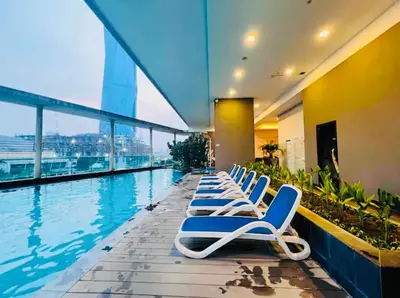 a row of lounge chairs next to a swimming pool at KL Homestay at Casa Residency- Walk to Lalaport & LRT in Kuala Lumpur