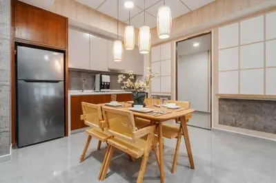 a kitchen with a wooden table and a refrigerator at Japandi 1BR Agile Bukit Bintang by RumaBnB in Kuala Lumpur