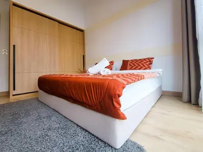 a bedroom with a large bed with an orange blanket at COL25A KL Tower Balcony 1Bedroom & Infinity Pool KLCC View in Kuala Lumpur