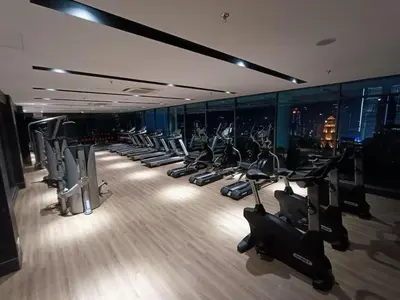 a gym with a row of treadmills and machines at COL 25B KLCC Infinity Pool View Studio in Kuala Lumpur