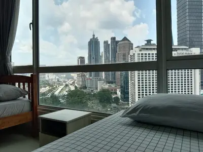 a bedroom with a large window with a view of the city at Hushed Dorm KL in Kuala Lumpur