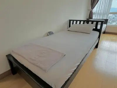a bed with white sheets and a pillow on it at Hushed Dorm KL in Kuala Lumpur