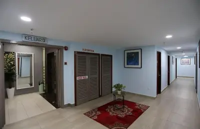 a hallway with two sets of doors and a red rug at Hotel La ISRA at Bukit Bintang in Kuala Lumpur