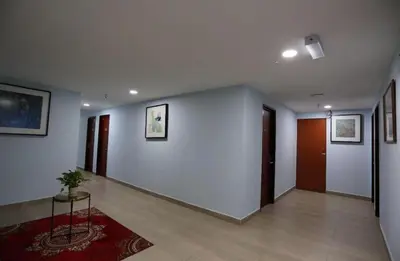 a hallway with white walls and a potted plant at Hotel La ISRA at Bukit Bintang in Kuala Lumpur