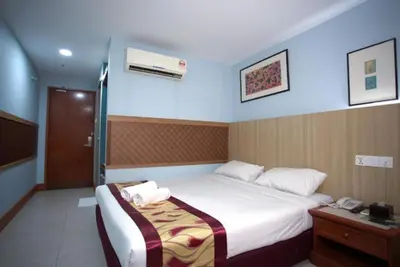 a hotel room with a bed and a telephone at Hotel La ISRA at Bukit Bintang in Kuala Lumpur