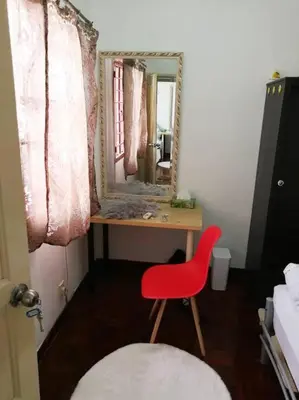 a red chair sitting in front of a desk with a mirror at Kuala Lumpur Homestay Bandar Sri Permaisuri in Kuala Lumpur