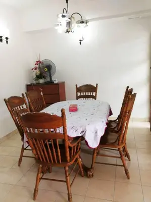 a dining room table with wooden chairs and a pink table cloth at Kuala Lumpur Homestay Bandar Sri Permaisuri in Kuala Lumpur