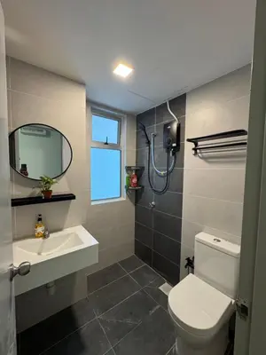 a bathroom with a toilet and a sink and a mirror at Studio Stay in Kuala Lumpur