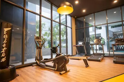 a gym with exercise equipment in a room with windows at Neu Suites By Cozy Unit L20RB near KLCC & Jelatek LRT in Kuala Lumpur